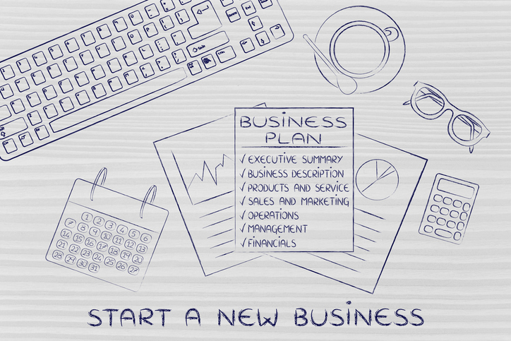 Business plan with sections on office desk, with text Start a new business
